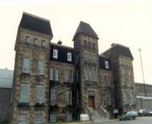 Front elevation of the Administrative Building, showing the masonry work consisting of freestone walls and corner quoins of dressed stone in a contrasting colour, 1990.; Correctional Service of Canada / Service correctionnel du Canada, 1990.