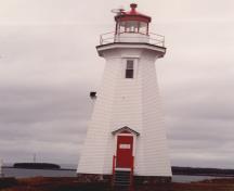 Vue de la façade du phare, qui montre la haute forme et le volume du bâtiment, 1989.; Transport Canada / Transports Canada, 1989.