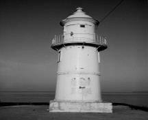 Vue générale du phare (avant), qui montre la volumétrie effilée formée d’une base en béton, de deux sections cylindriques et d’une attrayante coupole en métal où se trouve le feu, 1989.; Canadian Coast Guard / Garde côtière canadienne, 1989.
