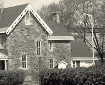 View of a façade of the Superintendent's House, showing the exterior walls of random coursed sandstone, 1985.; Parks Canada Agency / Agence Parcs Canada, 1985.