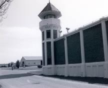 Side elevation of the Southern Tower D-3, showing the composition of the tower which consists of a concrete base, an octagonal shaft, and an octagonal observation gallery with a guard hut, 1994.; Agence Parcs Canada / Parks Canada Agency, 1994.