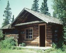 View of Grey Owl's Cabin, showing its peeled logs, wood shingles and exposed rafter tails.; Agence Parcs Canada / Parks Canada Agency
