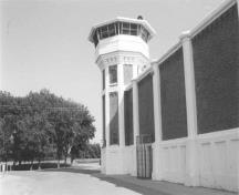 View of the Northern Tower D-1, showing the concrete base, an octagonal shaft, and a one-storey, octagonal observation gallery with a low hipped roof, 2002.; Agence Parcs Canada / Parks Canada Agency, 2002.