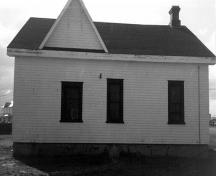 General view of the Fog Alarm Building, showing the one-and-a-half storey, rectangular massing with a gable roof and dormer, 1990.; Parks Canada Agency / Agence Parcs Canada, 1990.