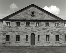 View of the main entrance of the Barrack, showing the frontispiece surmounted by a pediment with oculus which reflects a Palladian influence.; Parks Canada Agency / Agence Parcs Canada.