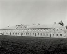 View of the exterior of the Barrack, showing the regular spacing of openings and the loopholes in the side wall.; Parks Canada Agency / Agence Parcs Canada.