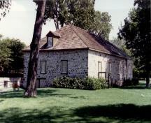Vue de l’entrepôt de la Baie d’Hudson, qui montre les murs de maçonnerie brute en pierres des champs.; Agence Parcs Canada / Parks Canada Agency.