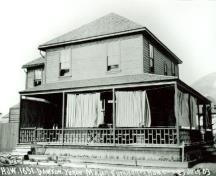 Side view of the Commanding Officer's Residence, showing the low hipped-roof with shingles, strong roof lines, and a full width verandah, 1903.; Library and Archives Canada/ Bibliothèque et Archives Canada, 1903.