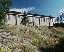 Vue de la façade générale du bâtiment 19, qui montre la disposition régulière des fenêtres à guillotine et des portes, vers 2004.; Parks Canada Agency / Agence Parcs Canada, circa/vers 2004.