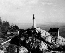 Photographie historique du Phare à la pointe Atkinson, où l'on peut apercevoir sa compatibilité avec son cadre marin sauvage, 1925.; Parks Canada Agency / Agence Parcs Canada, 1925