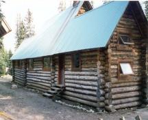 Rear elevation of the Stanley Mitchell Alpine Hut, showing the horizontally laid, peeled round logs with saddle-notched corners, 1998.; Parks Canada Agency/Agence Parcs Canada, 1998.