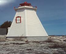 View of the exterior of the Light Tower, showing the white painted, narrow, wood shingle siding, 1990.; Department of Transport / Ministère des Transports, 1990.
