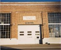 Vue en détail de la station de pompage, qui montre les motifs de brique à caractère ornemental et le panneau avec la pierre de date, 1985.; Department of Public Works / Ministère des Travaux publics, 1985.