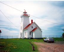 Vue de l'arrière du Phare et sifflet de brume à Wood Islands, où l'on peut apercevoir la lanterne en métal et en verre, la construction sur charpente en bois, et les fenêtres à guillotine à carreaux multiples aux châssis en bois, vers 1990.; Department of Transport / Ministère des Transports, ca./vers 1990.
