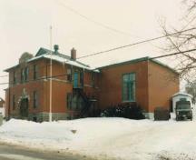 Vue générale du Manège militaire, qui montre les façades bien proportionnées avec l’ordonnancement symétrique des hautes fenêtres à guillotine en bois, 1990.; Department of National Defence / Ministère de la Défense nationale, 1989.
