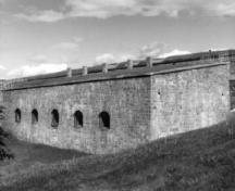 Vue générale du Bâtiment 24, montrant sa construction de maçonnerie solide et fonctionnelle, offrant une très bonne résistance aux bombes grâce à des plafonds voûtés, 1991.; Agence Parcs Canada / Parks Canada Agency, Rhona Goodspeed, 1991.