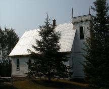 A brick chimney rises through the middle of the metal roof.; PNB 2005