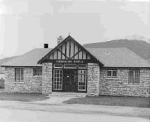 General view of the Rescue Building, showing the symmetrical placement of doors and small multi-paned casement windows, 1950.; Parks Canada Agency / Agence Parcs Canada, 1950.