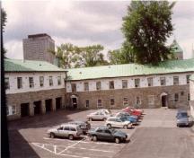 Vue du bâtiment 1, qui montre la volumétrie groupée sur deux étages avec un toit en appentis revêtu de cuivre, 1993.; Agence Parcs Canada / Parks Canada Agency, 1993.