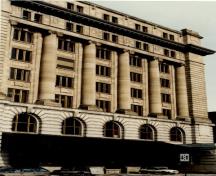 View of the Customs House, showing the eight-storey massing with classical Beaux-Arts tripartite composition of base, columns and entablature, 1989.; Ministère des Travaux publics / Department of Public Works, 1989.