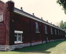 General view of RMC Building 3, showing the regular fenestration and modulation of the long elevations, 1993.; Parks Canada Agency / Agence Parcs Canada, 1993.