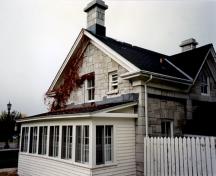 General view of RMC Building 2, showing the house-form, stone-clad, gable-roofed block with a central gable on the front, 1993.; Parks Canada Agency / Agence Parcs Canada, 1993.