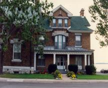 View of the main entrance of the RMC Building 27, showing the large front-facing gabled dormer, 1993.; Parks Canada Agency / Agence Parcs Canada, 1993.