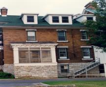 View of the exterior of RMC Building 27, showing the brick cladding with stone embellishments, 1993.; Parks Canada Agency / Agence Parcs Canada, 1993.