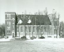 Side view of the Armoury, showing the gable-roofed drill hall, 1989.; Department of National Defence / Ministère de la Défense nationale, 1989.
