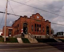 Vue de l'immeuble du gouvernement du Canada de North Head, où l'on peut apercevoir la façade plane interrompue par deux pilastres en brique en légère saillie, flanqués par les deux portes principales, 1993.; Public Works and Government Services Canada / Travaux publics et Services gouvernementaux Canada, 1993.