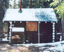 Side elevation of the Sandhills Warden Cabin, showing the rustic round-log wood construction style with saddle-notched corners, 1996.; Agence Parcs Canada / Parks Canada Agency, 1996.