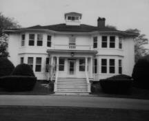 View of the main entrance of Ravenwood House, showing the symmetry of the three-bay, front façade with a one-storey entrance portico, 1991.; Department of Agriculture and Agri-Food/ Ministère de l'Agriculture et de l'Agroalimentaire , 1991