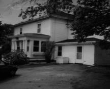 View of the south entrance of Ravenwood House, showing the classical detailing in the wood window surrounds, 1991.; Department of Agriculture and Agri-Food/ Ministère de l'Agriculture et de l'Agroalimentaire , 1991