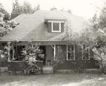 View of the main entrance of Limberlost, showing the incorporation of local materials and Rustic elements which contribute to the cottage’s picturesque quality, including cedar-shingle siding, 1992.; Parks Canada Agency / Agence Parcs Canada / Historica Resources Ltd., 1992.