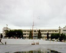 Façade latérale du bâtiment 34, qui montre l’agencement des fenêtres de métal en longues rangées, ce qui accentue le caractère horizontal du bâtiment, 1993.; Department of National Defence / Ministère de la Défense nationale, 1993.