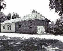 Vue de l'arrière de la résidence du maître-éclusier, qui montre les murs extérieurs épais en pierres posées en assises régulières, 1989.; Parks Canada Agency / Agence Parcs Canada, Couture, 1989.