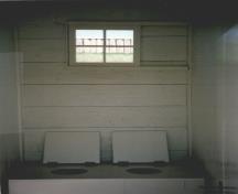 Vue du bâtiment des latrines, qui montre les latrines pour les femmes, 1992.; Agence Parcs Canada / Parks Canada Agency, 1992.