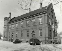 View of the side of the Armoury, showing the large, rectangular massing under a gable roof, 1991.; Department of National Defence / Ministère de la Défense nationale, 1991.