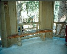 Interior view of Devonian Pavilion, showing the flag stone floor and the burl specimens utilized for the tie beams and bench legs, 1997.; Agence Parcs Canada / Parks Canada Agency, 1997.