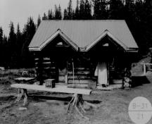General view of the Former Bathhouse, showing its simple massing as a gable-roofed structure with a shed-roofed extension along the back, 1994.; Agence Parcs Canada / Parks Canada Agency, 1994.