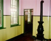 Vue intérieure du poste de garde représentant la salle de séjour qui donne sur la cuisine.; Agence Parcs Canada / Parks Canada Agency, J. Mattie, 1997.