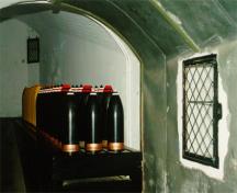 Intérieure du dépôt de munitions de la batterie inférieure montrant le côté gauche de l'ère de rangement des obus, 1997; Agence Parcs Canada / Parks Canada Agency, J. Mattie, 1997.