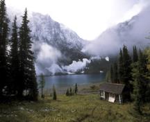View of the rear of the Floe Lake Warden Patrol Cabin, showing the use of natural, local materials such as the tightly scribed, horizontal, peeled log wall construction, 2005.; Parks Canada Agency / Agence Parcs Canada, C. Siddal, 2005.