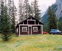 Facade of front(west) elevation, demonstrating the simple, symmetrical and well-proportioned composition of this square building which features a medium-pitched gabled roof that projects forward to cover an open porch along its front façade, 1999.; Cultural Resource Services, Calgary/Ressources culturelles, Calgary, 1999.