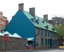Vue de coin de la maison Maillou démontrant la composition équilibrée de la façade avant, avec ses baies et fenêtres disposées symétriquement, de part et d’autre de l’entrée principale, 2003.; Parks Canada Agency / Agence Parcs Canada, 2003.