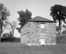 General view of the North Magazine, showing the rectangular plan, the use of solid masonry walls made from Chazy limestone, the low-slope hipped roof and the minimal decoration.; Parks Canada Agency / Agence Parcs Canada.