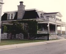 View of the front entrance of RMC Building 55, showing the prominent main elevation, with its broad and high porch, columns and stone staircase, 1993.; Parks Canada Agency / Agence Parcs Canada, 1993.