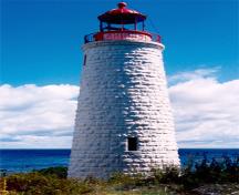 Vue générale du phare de l'île Griffith démontrant sa haute forme ronde légèrement fuselée qui se termine par un encorbellement légèrement saillant qui forme un balcon de veille et une base pour le lanterneau, 1990.; Canadian Coast Guard / Garde côtière canadienne, 1990.