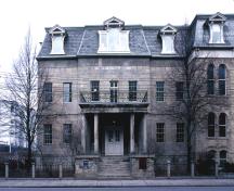 Facade of the Bank of Upper Canada Building showing the Neoclassical portico, consisting of: a raised podium; paired columns; a strongly defined entablature; and a second-storey balcony.; Parks Canada \ Parcs Canada, n.d.