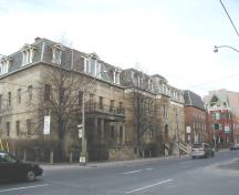 Vue panoramique de la Banque-du-Haut-Canada (gauche) montrant  l'organisation de la structure d'origine, comportant sept baies en façade et quatre baies sur les côtés, créant un volume imposant mais compact compatible avec ses alentours, 2003.; Parks Canada Agency / Agence Parcs Canada, 2003.